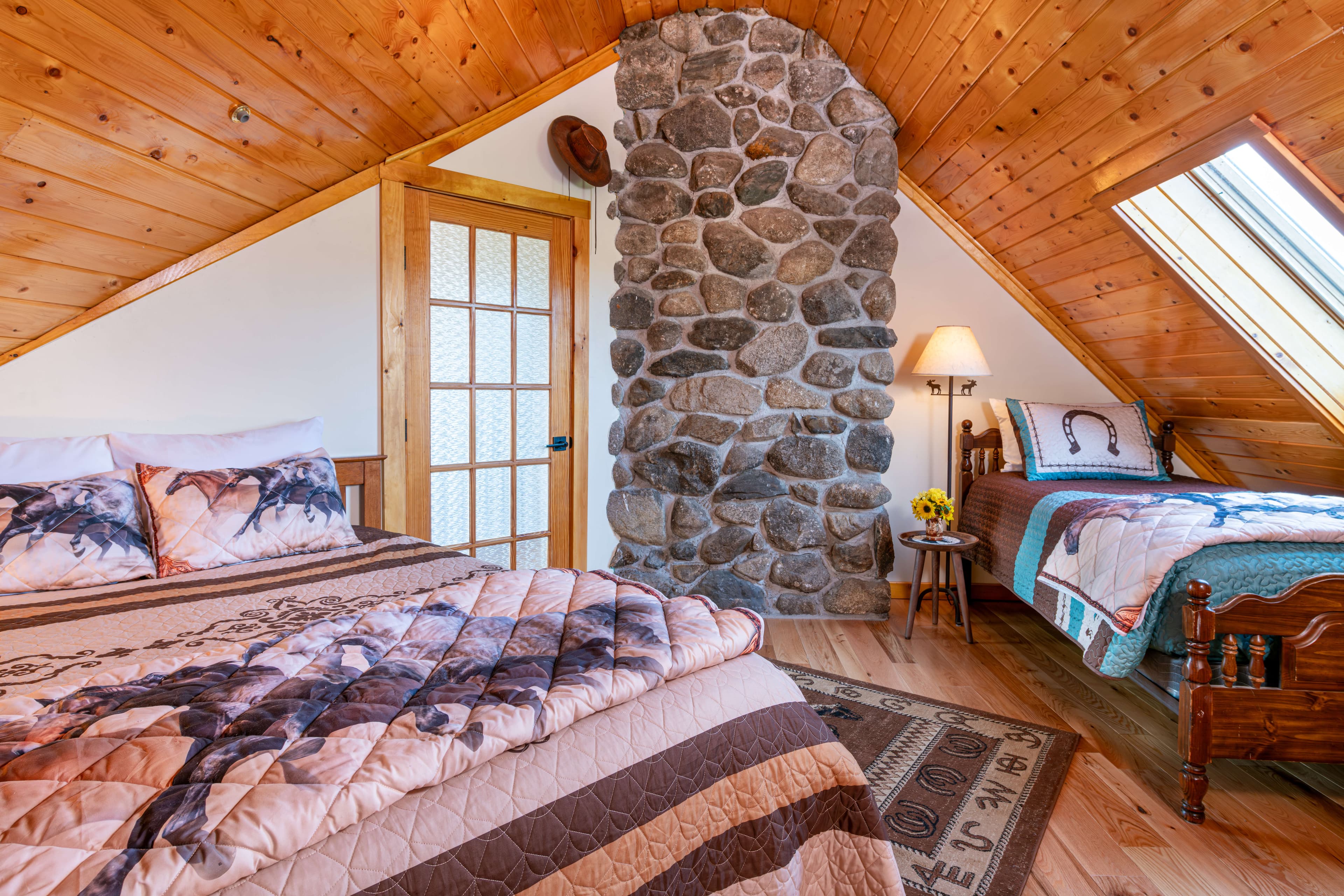 Queen bed and twin bed with a stone fireplace