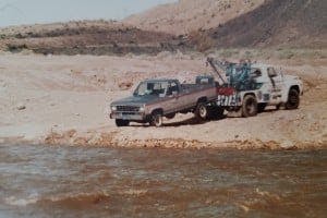 A tow truck towing a Ford Ranger truck