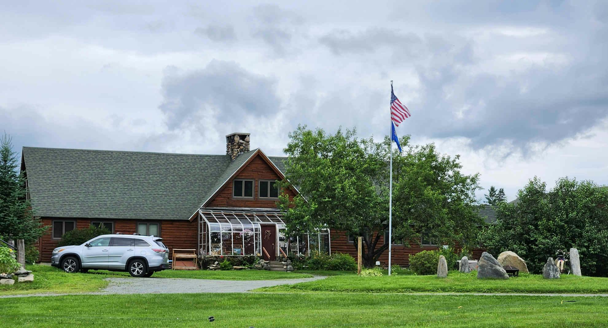 Exterior view of the Inn at Oxbow Acres with flags prominently displayed.