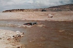 A partially submerged vehicle in a flooded area.